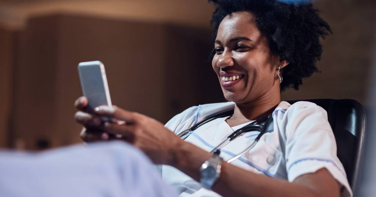 medical professional looking at her phone and smiling